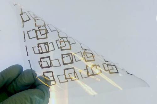A photograph of what looks like a thin, bendy piece of plastic covered with a pattern of almost-complete golden squares